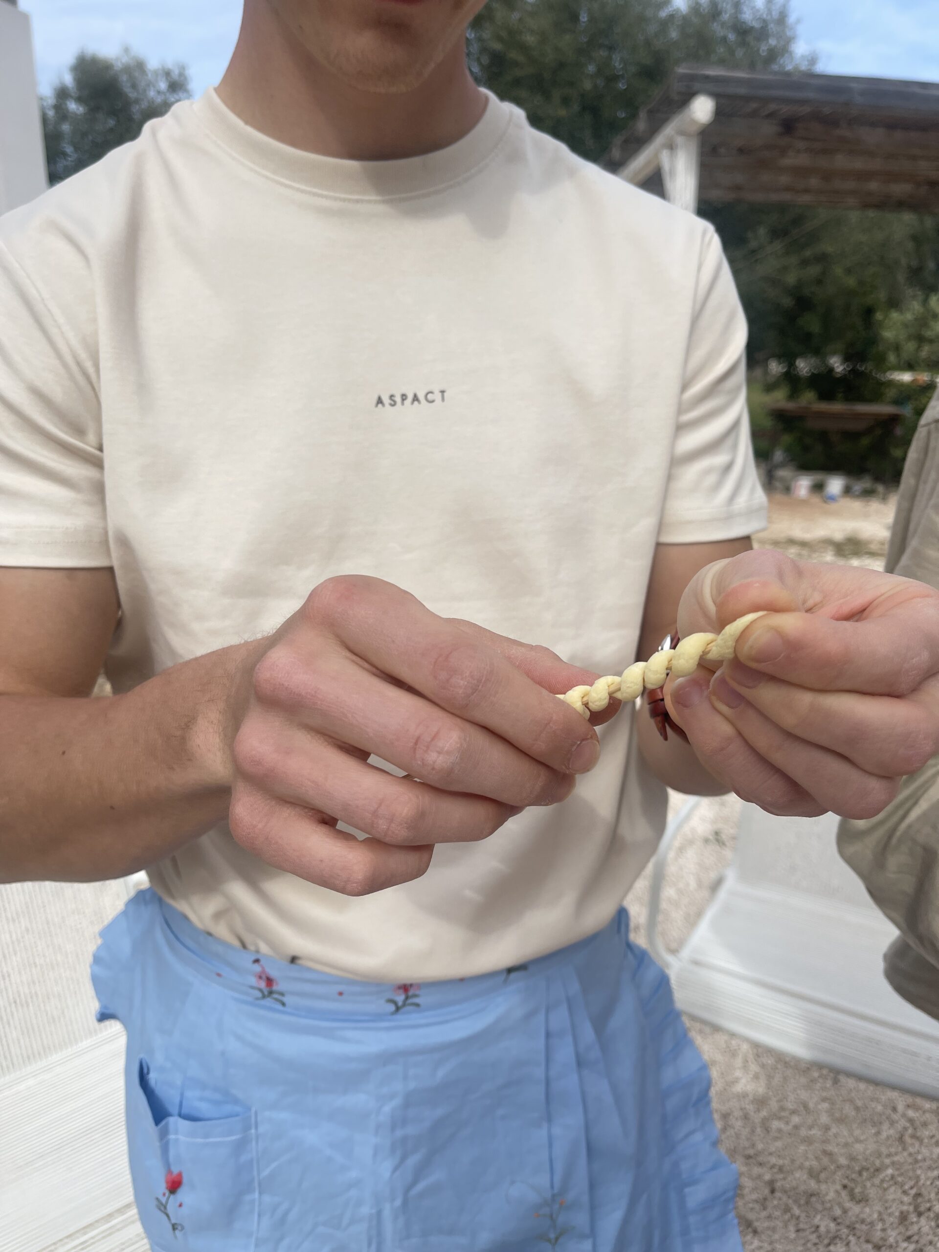 Dettaglio delle mani durante la creazione di pasta fatta a mano in un laboratorio di tradizioni pugliesi